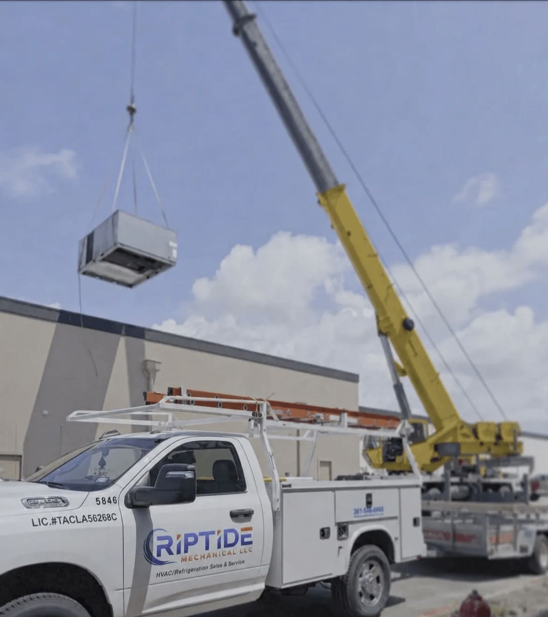 A rooftop unit being set by crane on a commercial building