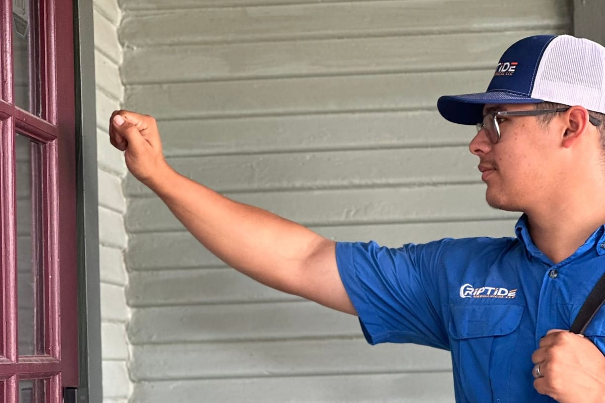 A Riptide Mechanical technician knocking at a customer front door at the start of a visit