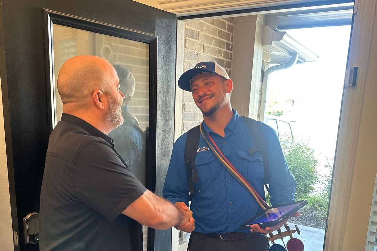 A Riptide Mechanical technician shaking hands with a homeowner at their front door at the end of a visit