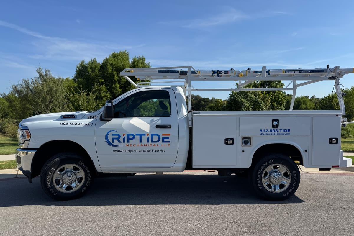 A Riptide Mechanical service truck photographed side on, the Austin number 512-893-TIDE and licence TACLA56268C readable on the body